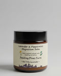 Jar of Lavender & Peppermint Magnesium Balm from Peaking Pines Farm on a wooden surface with a brown background